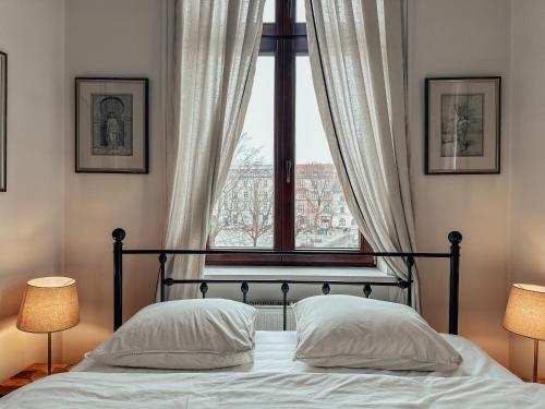 1 dormitorio con 1 cama y ventana grande en Once Upon a Time in Cracow - Old Town Apartment en Cracovia