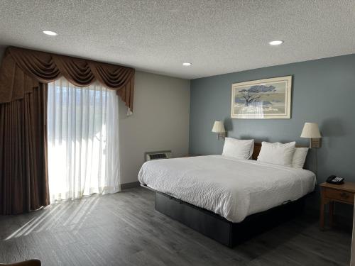 a bedroom with a bed and a large window at Days Inn by Wyndham Medford in Medford