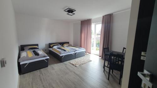 a bedroom with two beds and a table at JURA PARADISE in Olsztyn