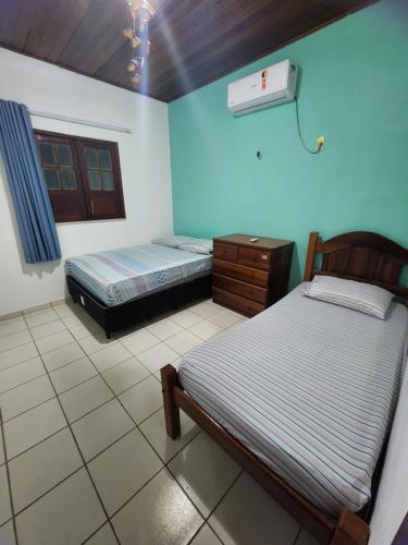 1 dormitorio con 2 camas y vestidor en Casa no atalaia na rua atalho, en Salinópolis