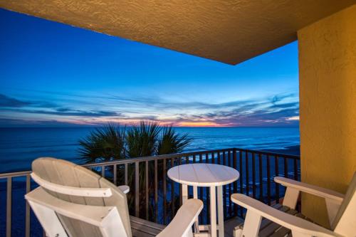 a balcony with chairs and a table and the ocean at Huge Beachfront Condo on Maderia Beach in St. Pete Beach