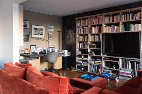 a living room with two orange couches and a television at Spacious apartment near Champ-de-Mars in Paris