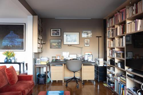 a office with a desk and a chair in a library at Spacious apartment near Champ-de-Mars in Paris