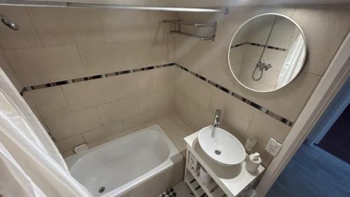a bathroom with a sink and a tub and a mirror at Apartamento Flowers in Buenos Aires