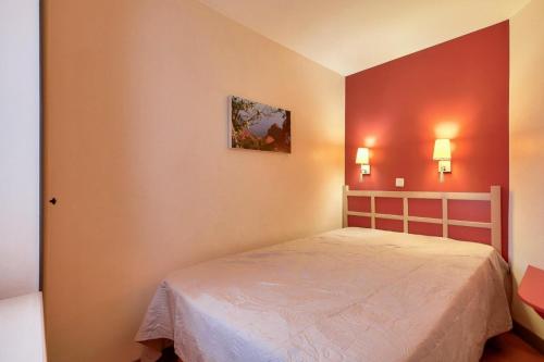 - une chambre avec un lit et deux lumières sur le mur dans l'établissement Résidence le Village de Cap Esterel - maeva Home - Appartement 2 pièces 5 personnes climatisé - Sélection MAE-8344, à Saint-Raphaël