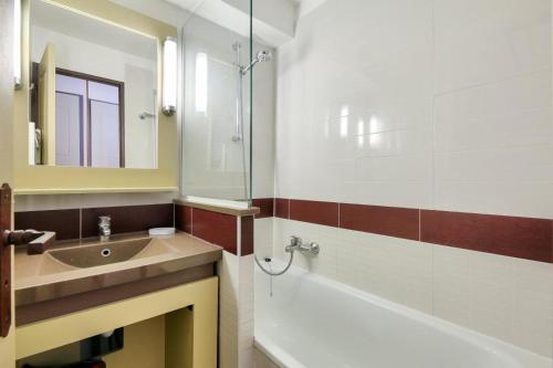 une salle de bain avec un lavabo, une baignoire et un miroir dans l'établissement Résidence le Village de Cap Esterel - maeva Home - Appartement 2 pièces 5 personnes climatisé - Sélection MAE-8344, à Saint-Raphaël