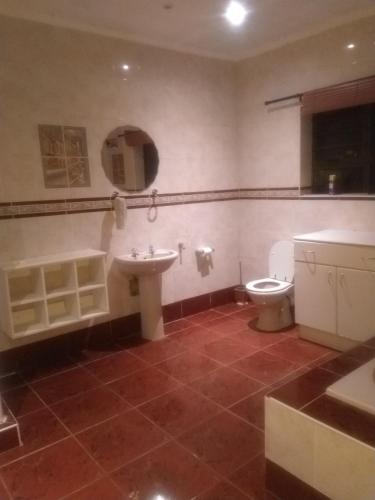 a bathroom with a toilet and a sink at Old style Room @48 in Gqeberha