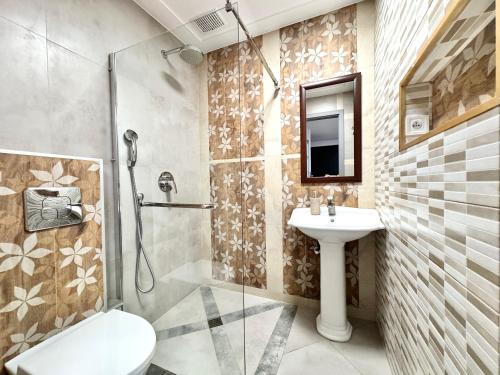 烏斯特卡的住宿－Apartamenty Marea Rentals Beniowskiego Ustka，带淋浴、卫生间和盥洗盆的浴室