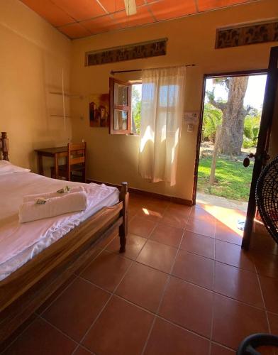 1 dormitorio con 1 cama y puerta corredera de cristal en Hostal Casa Bonita Ometepe, en Rivas
