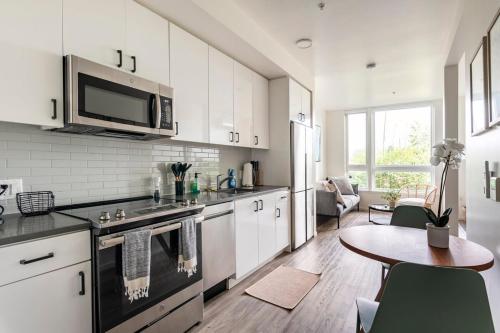 a kitchen with white cabinets and a table in it at Open One-Bedroom in West Oakland in Oakland