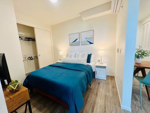 Open One-Bedroom in West Oakland في آوكلاند: غرفة نوم بسرير ازرق ومكتب