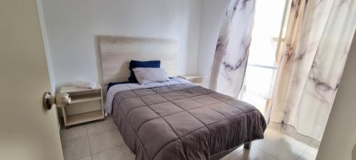 um quarto com uma cama num quarto com uma janela em Depa cerca Antea Villas A em Querétaro