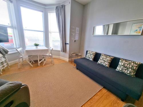 a living room with a couch and a table at Portrush by the Sea - 1 West Beach in Portrush