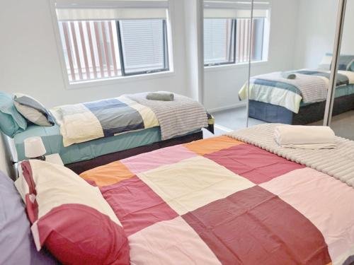 a room with two beds and two mirrors at Inn Central Townhouse at Canberra in Canberra