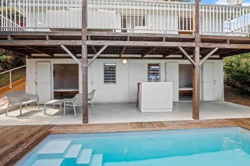 a patio with a swimming pool and a house at Villa Olive O in Le Robert