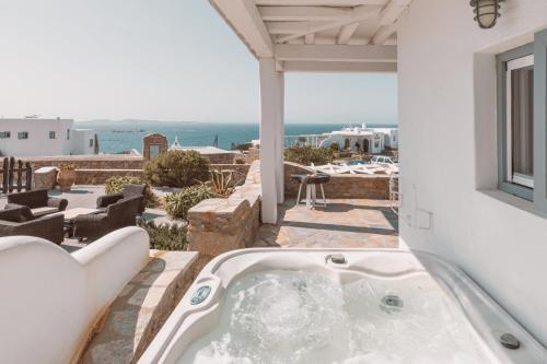 d'une baignoire sur la terrasse avec vue sur l'océan. dans l'établissement Villa Konstantin, à Mykonos
