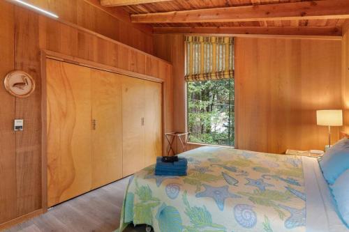 a bedroom with a bed and a window at Grandma's Cabin by the Sea in Gualala