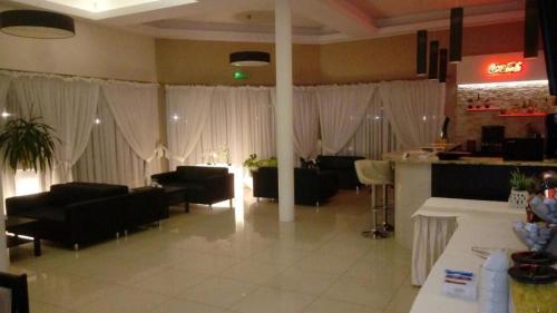 a living room with white drapes and tables and chairs at Hotel Graal Targowisko in Targowisko