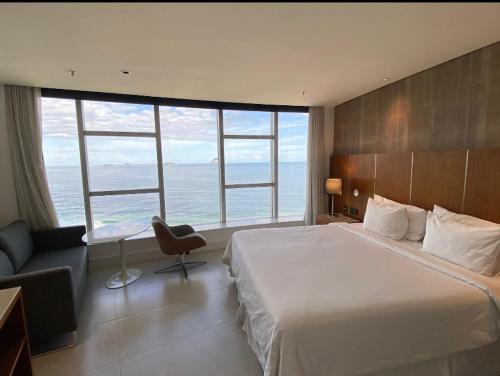 Habitación de hotel con cama grande y ventanas grandes. en Apart Hotel en Río de Janeiro