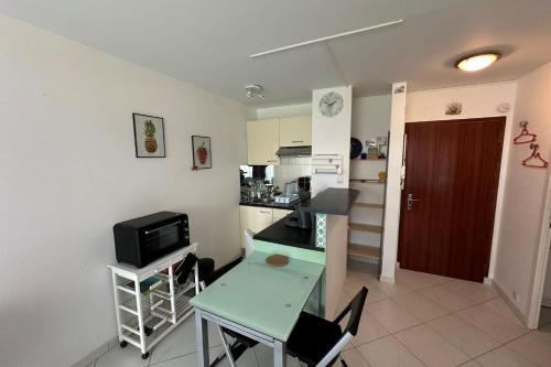 une petite cuisine avec une table et une petite table et des chaises dans l'établissement Cosy love cocoon close to the sea, à La Baule