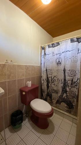 a bathroom with a toilet and a shower curtain at Hostal Casa Bonita Ometepe in Rivas