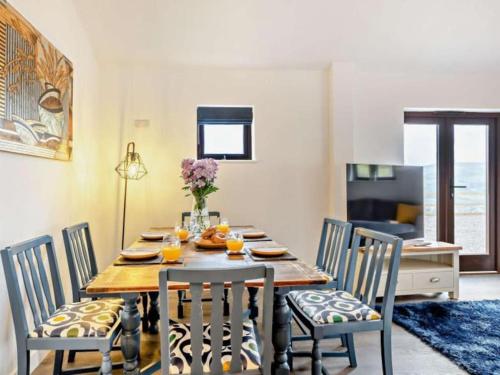 una sala da pranzo con tavolo, sedie e succo d'arancia di Hillsview - 4 berth renovated barn conversion a Combe Martin