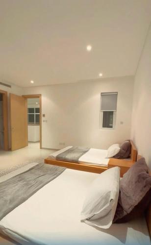 1 Schlafzimmer mit 2 Betten und einem Fenster in der Unterkunft LUXURY 4 Bedroom Private Pool Villa at THE WAVE in Muscat