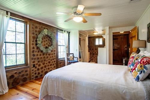 a bedroom with a white bed and a ceiling fan at A Rustic Romantic Getaway in Texas Hill Country in San Marcos