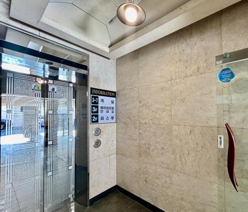 a lobby with a elevator and a glass door at A ONE Motel in Geoje