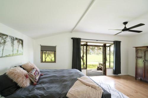 1 dormitorio con 1 cama y ventilador de techo en Linleigh Farmhouse With Mountain Views, en Barwite