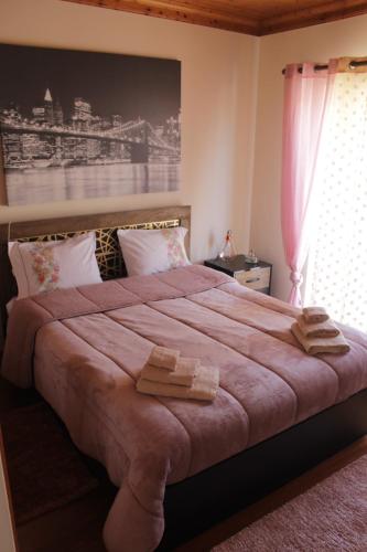 a bedroom with a large bed with two towels on it at Casa das Laranjeiras in Alqueidão da Serra