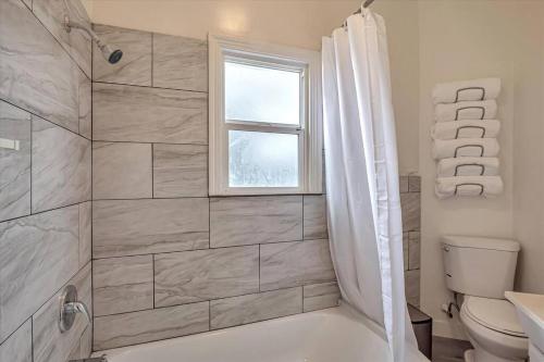 La salle de bains est pourvue d'une douche, de toilettes et d'une fenêtre. dans l'établissement Charming downtown Livermore Flat - Private Living space, à Livermore