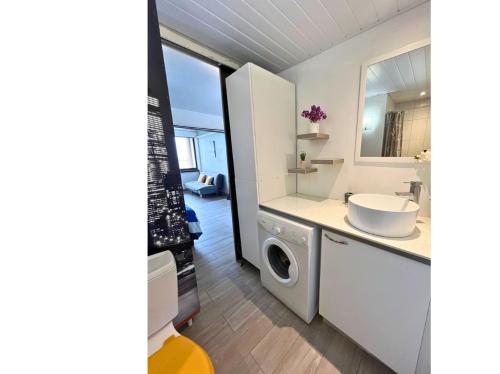 a bathroom with a sink and a washing machine at Studio Teiki - calme, proche centre-ville, ferry & aéroport in Papeete