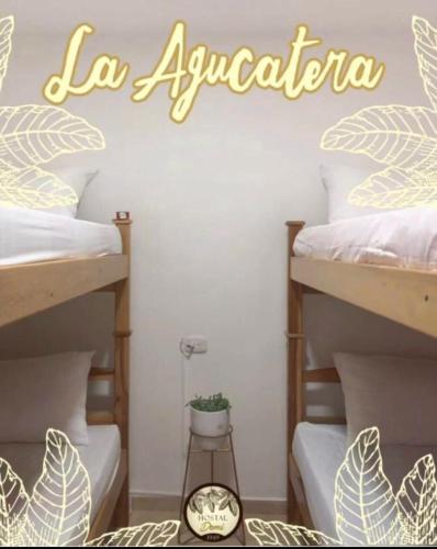 una camera con due letti a castello con un cartello che legge la aquaria di Hostal Domi1949 a San Vicente de Chucurí