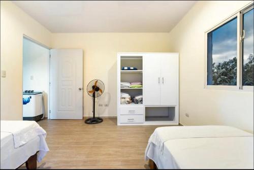 two beds in a room with two windows at apartamento EL CORAL in Río San Juan