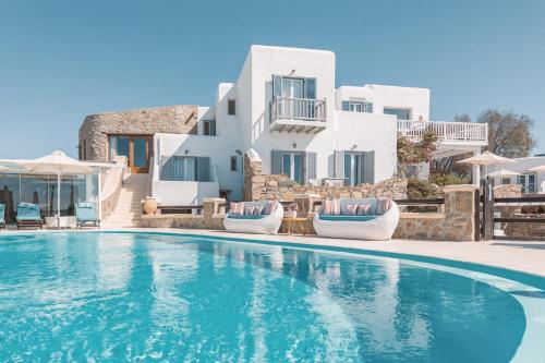 una piscina frente a una villa con edificios blancos en Villa Konstantin, en Mykonos ciudad