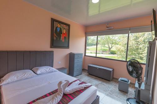 a bedroom with a bed and a fan and a window at THE HOUSE of FLOWERS in Melgar