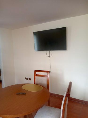 Habitación con mesa y TV en la pared. en Minidepartamento amoblado, en Arequipa