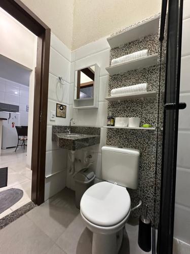 ein Badezimmer mit einem weißen WC und einem Waschbecken in der Unterkunft Residencial Paraiso in Sinop