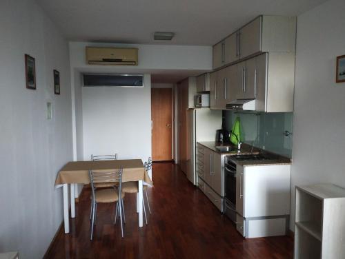 una pequeña cocina con mesa, mesa y sillas en Departamento calle 2 en La Plata