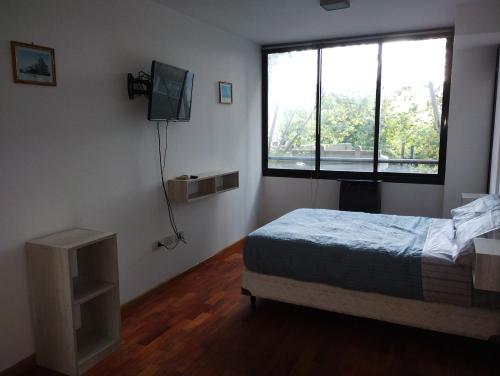 1 dormitorio con cama y ventana grande en Departamento calle 2 en La Plata