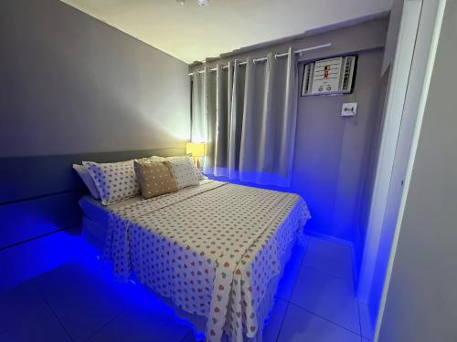 a bedroom with a bed with a blue light at FLAT Boa Viagem - 50m da Praia - Garagem GRÁTIS - 24H CHECK IN - in Recife