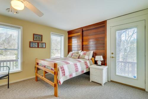 ein Schlafzimmer mit einem Bett und zwei Fenstern in der Unterkunft Duck and Bugs Cabin on Boone Lake with Boat Dock! in Piney Flats