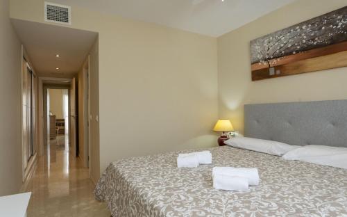 a bedroom with a bed with two white towels on it at Golf Deluxe in La Alcaidesa
