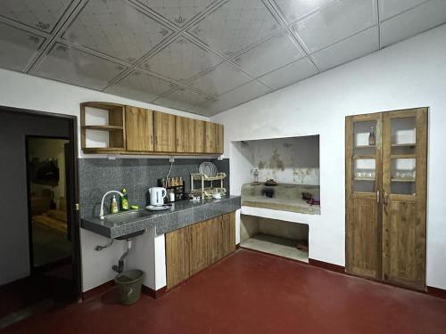 uma cozinha com armários de madeira e um lavatório em soha bungalow-escape the city em Kurunegala