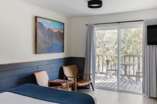een slaapkamer met een bed en een balkon bij LOGE Leavenworth Riverside in Leavenworth