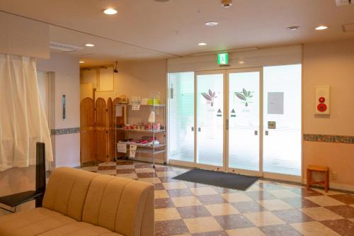 a waiting room with a couch in a room with skis at ホテル森のしずく in Shimoda