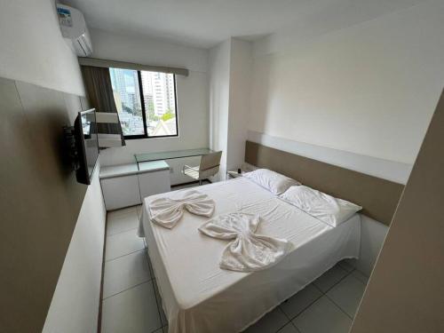 1 dormitorio con 1 cama con sábanas blancas y espejo en Apt Completo, 2 QTS, 2 WC e próx ao mar, en Recife