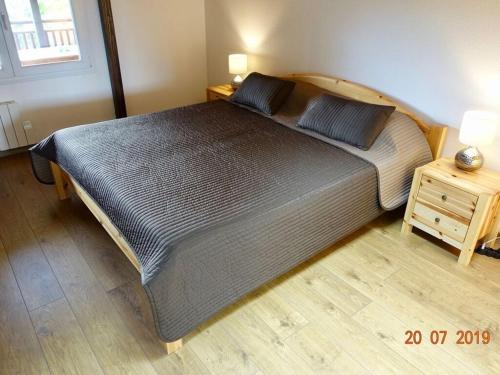 een groot bed in een slaapkamer met een nachtkastje bij Classy apartment in Soultzeren in Soultzeren
