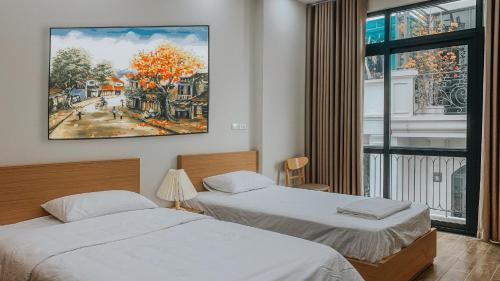 2 camas en una habitación con un cuadro en la pared en Yen’s House en Hanói